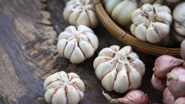 heads of garlic and shallot bulbs in basket