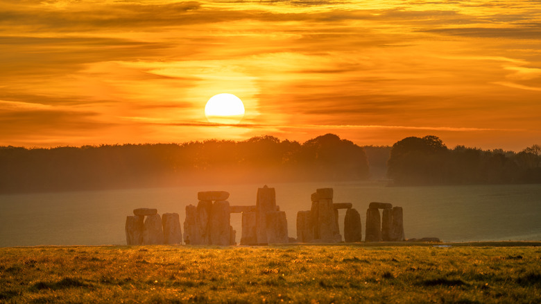 Sunrise above Stonehenge among a misty landscape