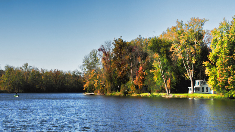 A white house surrounded by fall foliage overlooking Lake Onondaga in Liverpool, New York.