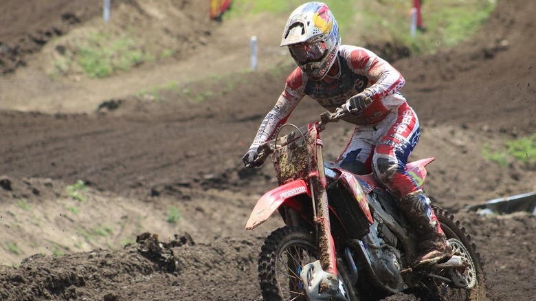 A muddy driver on a motorcycle participating in Redbud Motocross