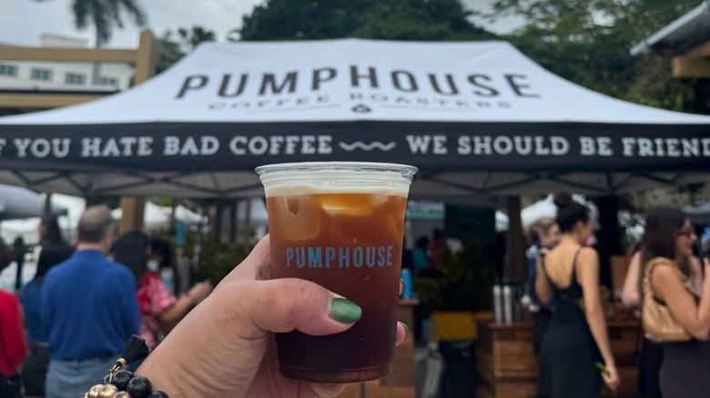 hand holding coffee that says Pumphouse