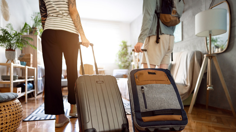 A couple walking with their suitcases