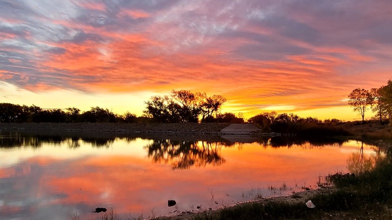 Fiery sunset colors reflecting on the lake at Meade State Park, Kansas