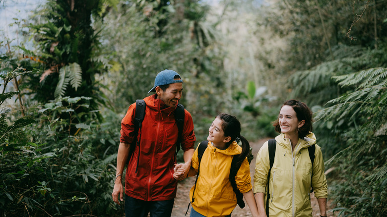 Smiling family walking along wooded path