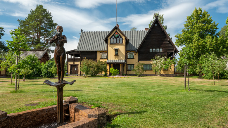 Artist house and gardens with statue on a sunny day