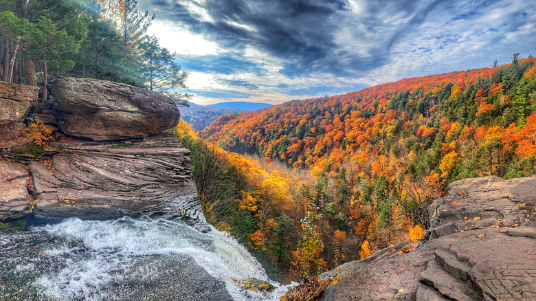 Waterfall crashing into fall foliage mountain