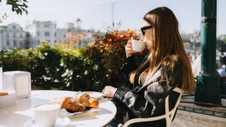 A woman drinking coffee at breakfast in Venice