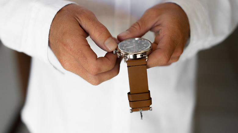 Someone setting the time on their watch