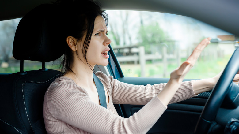 Woman driver gesturing in annoyance at traffic