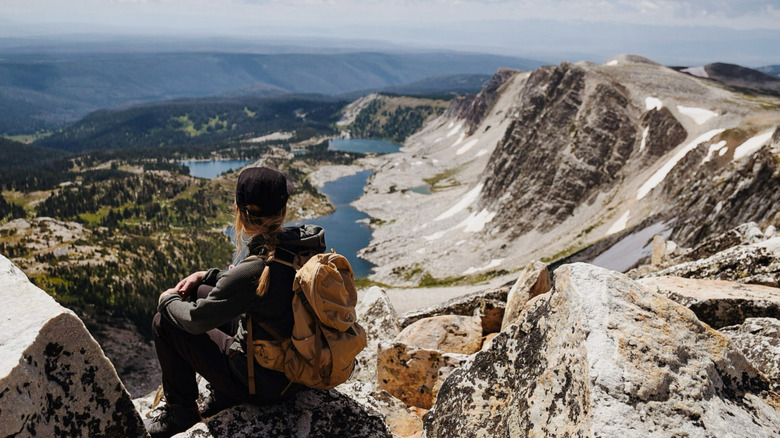 A woman sits atop a peak in Wyoming