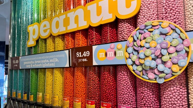 Row of dispensers with colorful Peanut M&M candies along a wall at the M&M's World store in Times Square, Manhattan, New York City