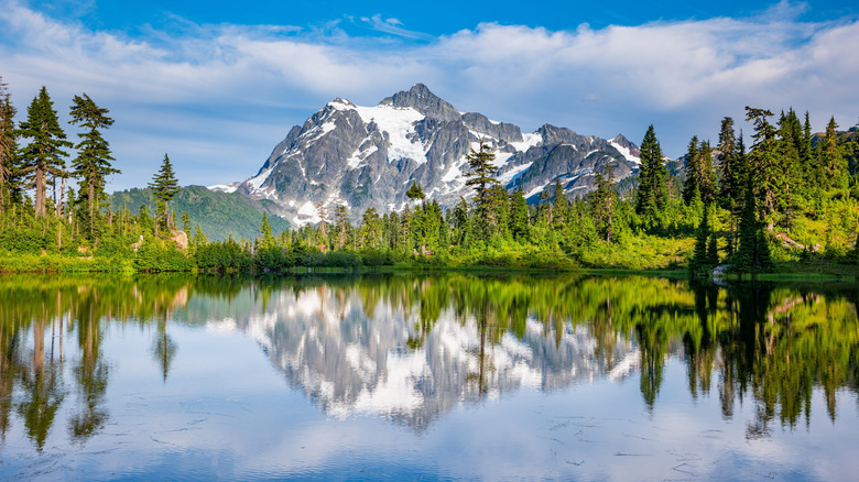 Snow-covered mountains and a lake surrounded by forest in North Cascades National Park