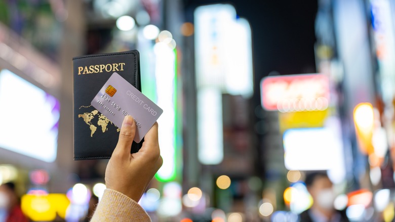 Person holding a passport and credit card