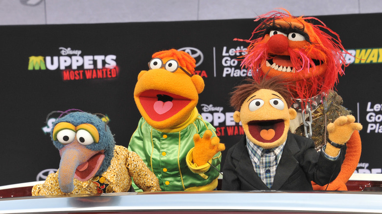 Characters from The Muppets behind a desk