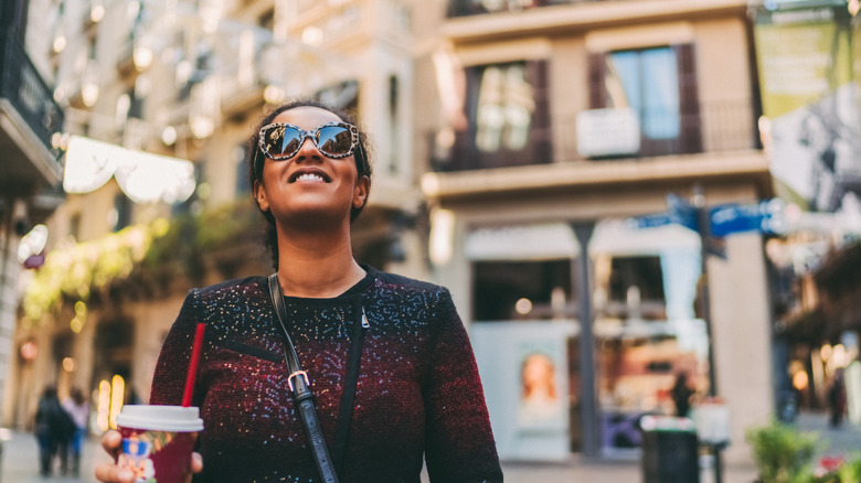 Smiling woman holding a drink while in Spain