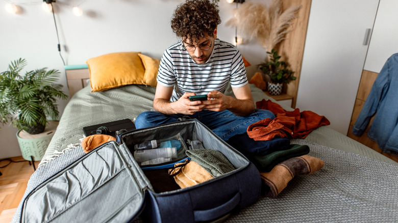 A man planning and packing for a trip