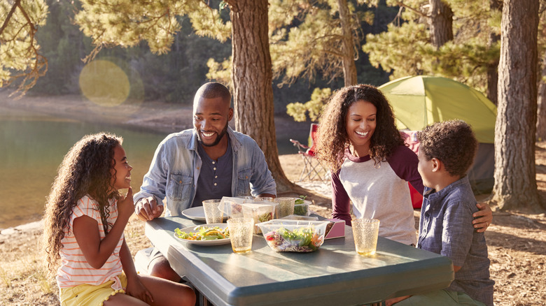 A family eating outdoors while camping