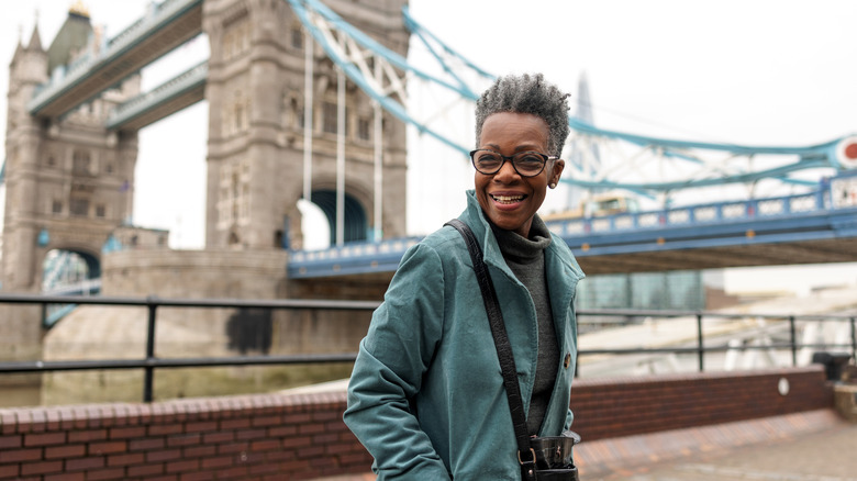Happy traveler in London with a bridge in the background