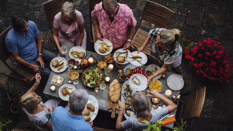 Friends eating outdoors together with a Mediterranean spread
