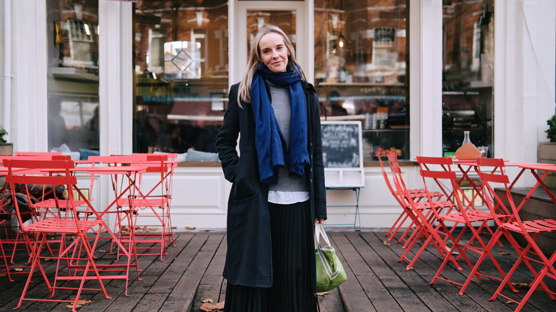 Stylish woman standing in front of cafe in Europe