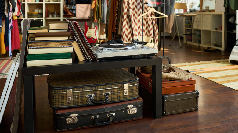 Vintage suitcases are stacked among other items in a specialty shop