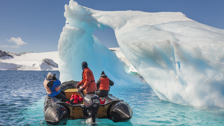 A motorboat approaches an ice formation in Antarctica
