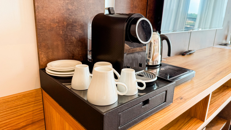 Hotel room stocked with coffee maker and mugs