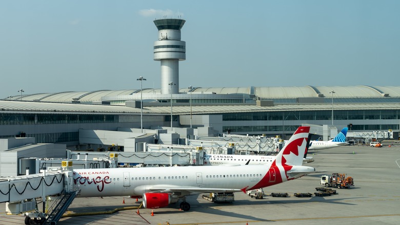 A view of an Air Canada aircraft and air traffic control tower at Toronto Pearson Airport.