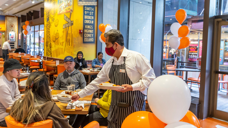 Waiter serving cheesecake at Junior's