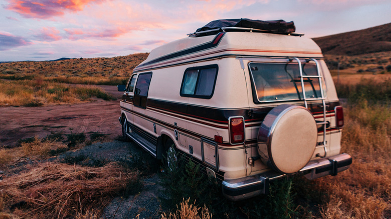 A parked RV camper with a sunset in the background
