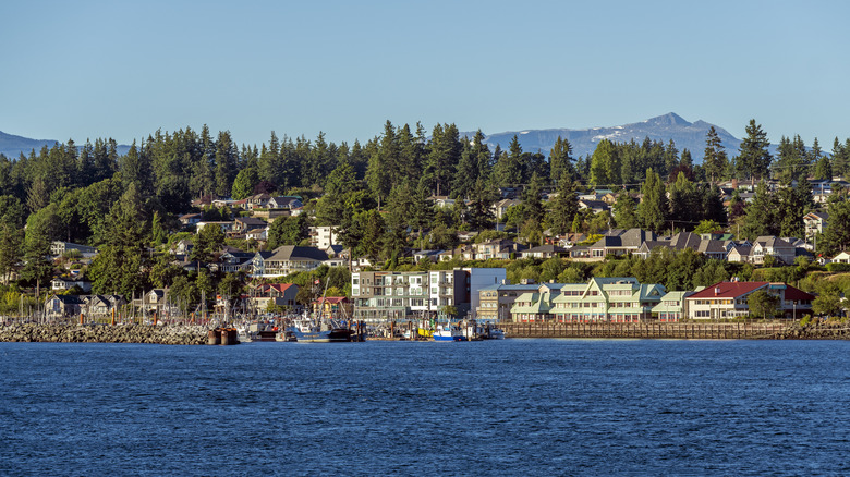 Campbell River's harbor and waterfront restaurants with evergreens and snow-capped mountains in the background.