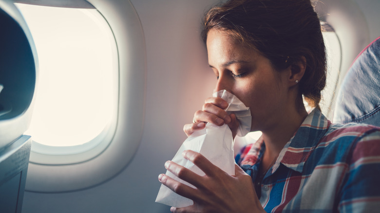 Woman breathing in bag on plane