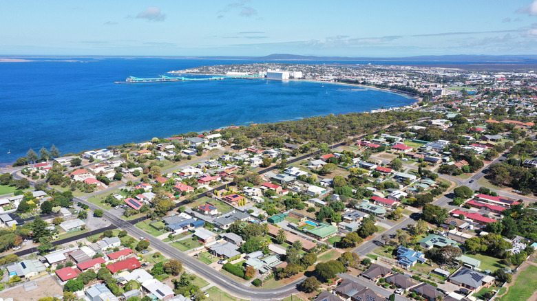 Houses and trees in city along coast and ocean