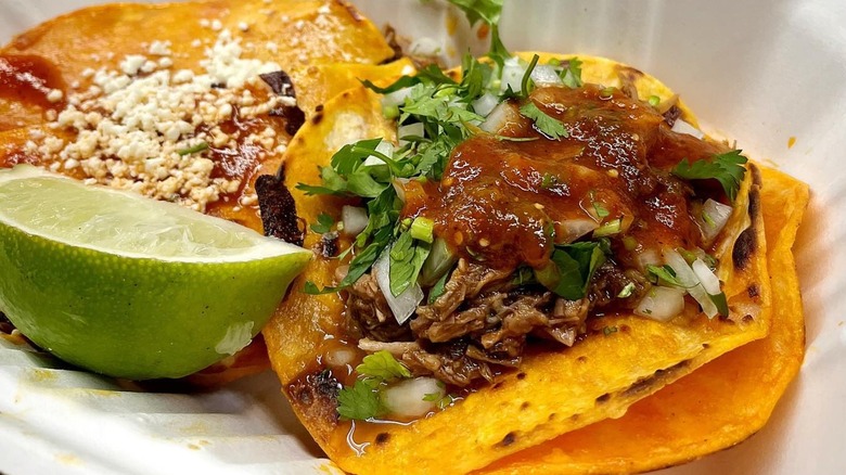 A taco and lime in a to-go box from Birria-Landia
