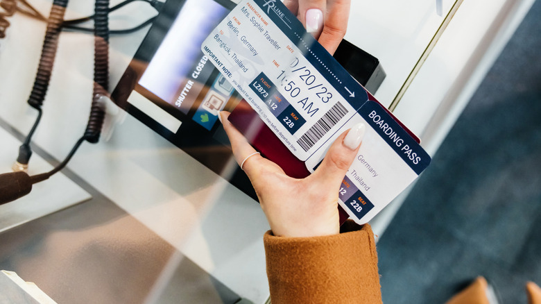 A close up of someone handing their boarding pass