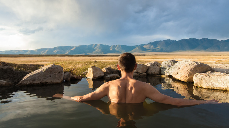 A person looking at the view from one of the pools at Wild Willy's Hot Spring