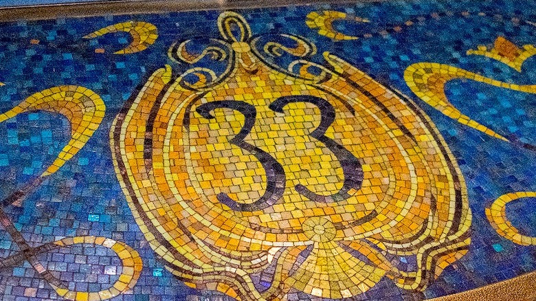 A mosaic Club 33 logo outside the entrance to a secret lounge in a Disney theme park.