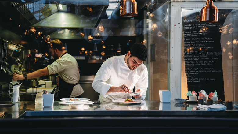 A chef garnishing a plate