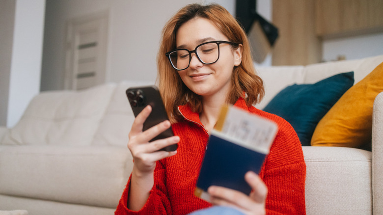 A woman checking flights on her smartphone