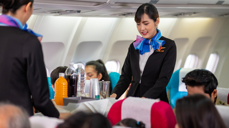 flight attendant pushing drinks cart