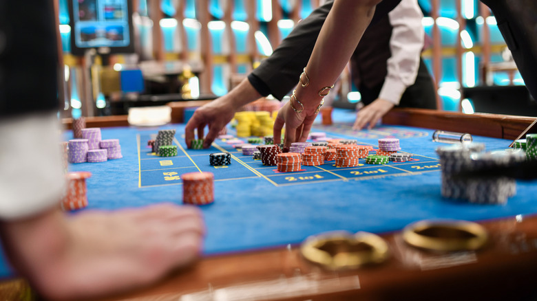 The hands of gamblers move chips around a gaming table in a Las Vegas casino