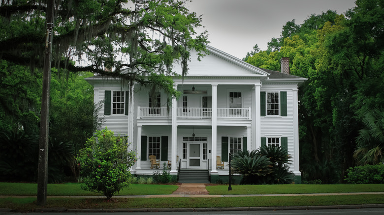 A white, historic home with rocking chairs on the porch in Monticello, Florida.