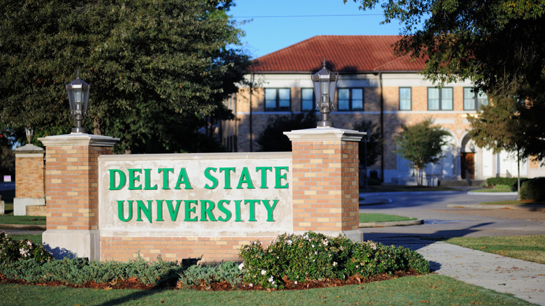 A brick building on the campus of Delta State University with a marker sign