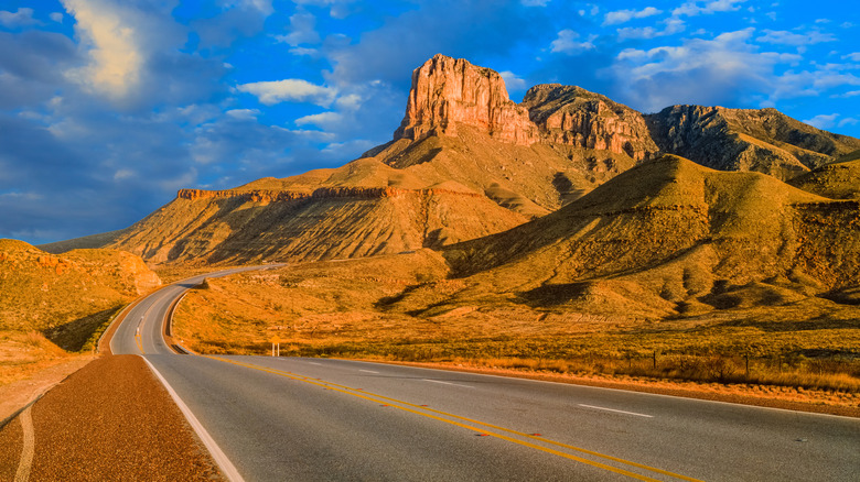 Curving road with mountain landscape in the background.