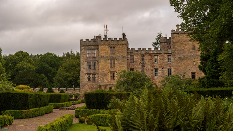 Long view of the haunted Chillingham Castle in summer