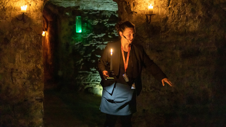 A guide walks through the dimply lit caverns hidden beneath the streets of Edinghburgh