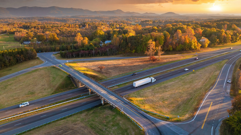 Highway interchange with cars and trucks at sunset
