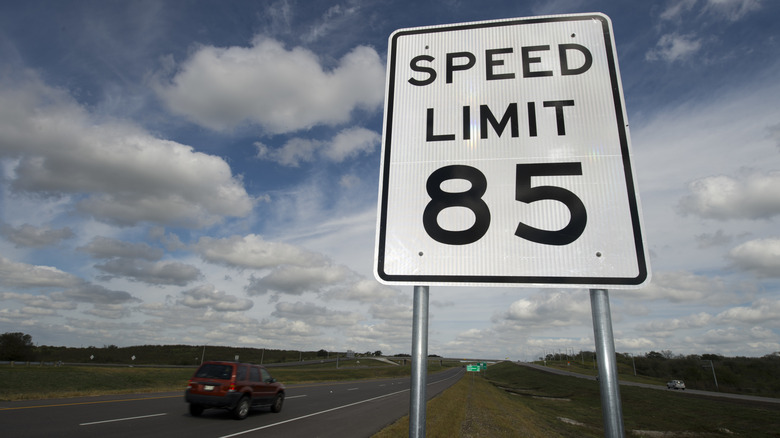 A sign posting a speed limit of 85 mph on a highway