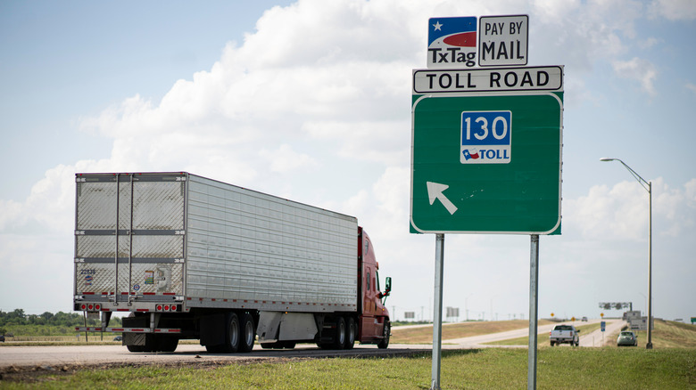 A sign for Texas State Highway 130 with a truck on the highway