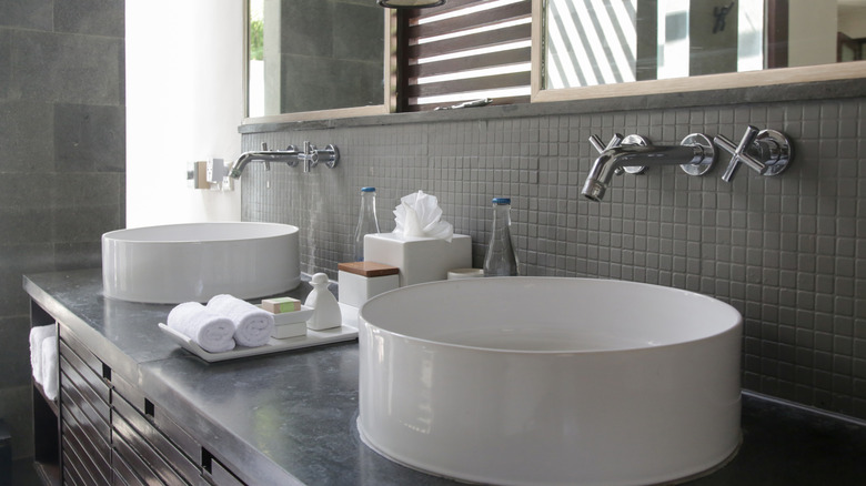 A hotel bathroom sink with towels and toiletries